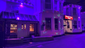 Et hotel med et skilt, der viser "Preston Park Hotel", samt en bar med synligt indre lys.