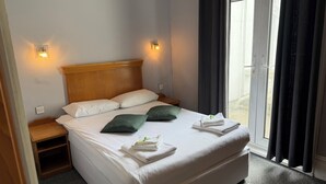 En pænt redt seng med puder, et natbord og et sengebord.