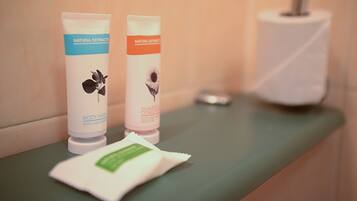 Two bottles of body wash and a towel on a bathroom counter.