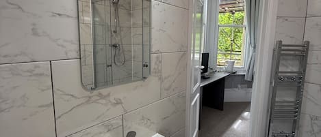 A bathroom with a white sink, a mirror, and a shower.