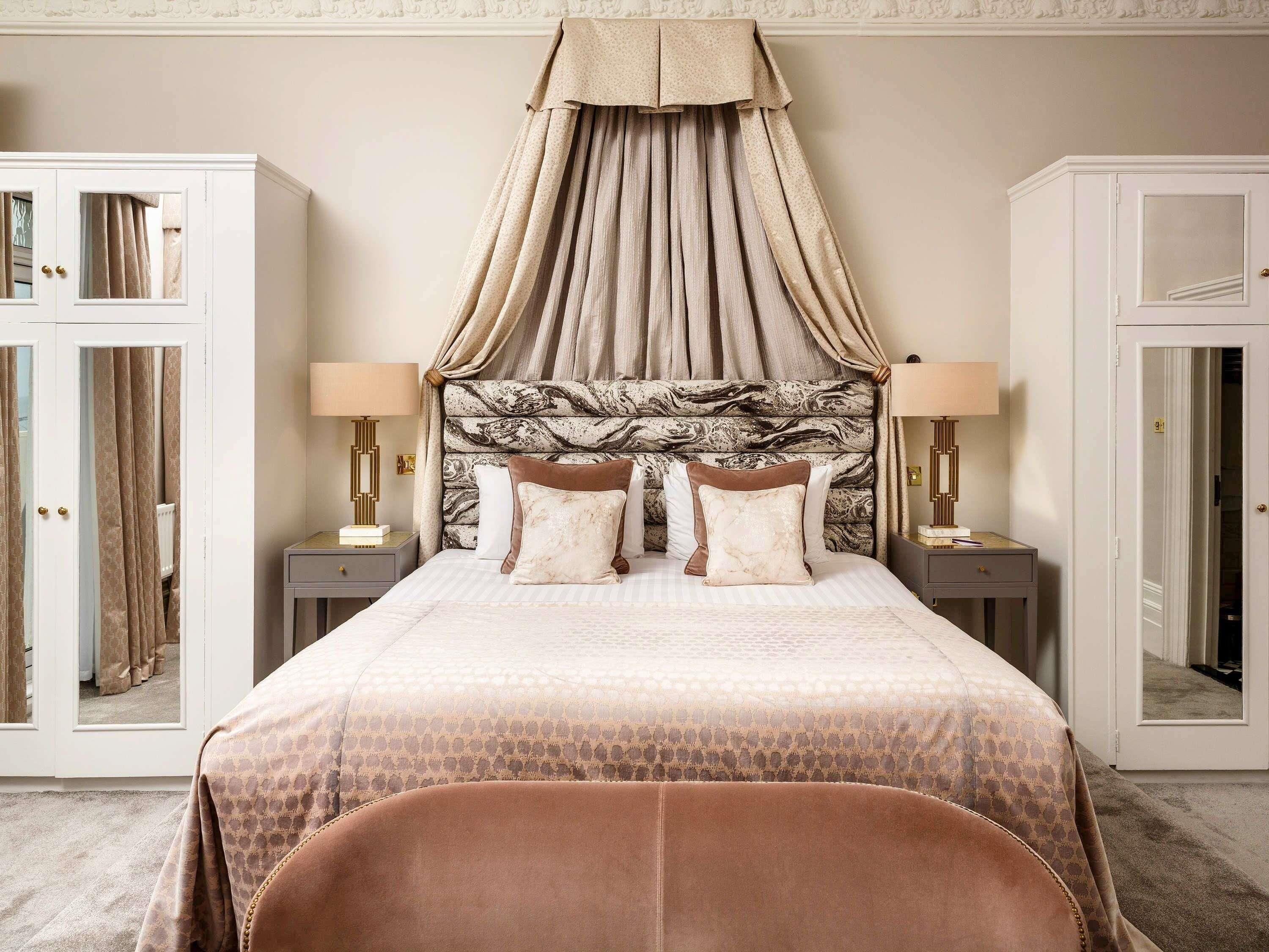 Une chambre à coucher comprenant un lit, des tables de chevet, une armoire et une chaise.