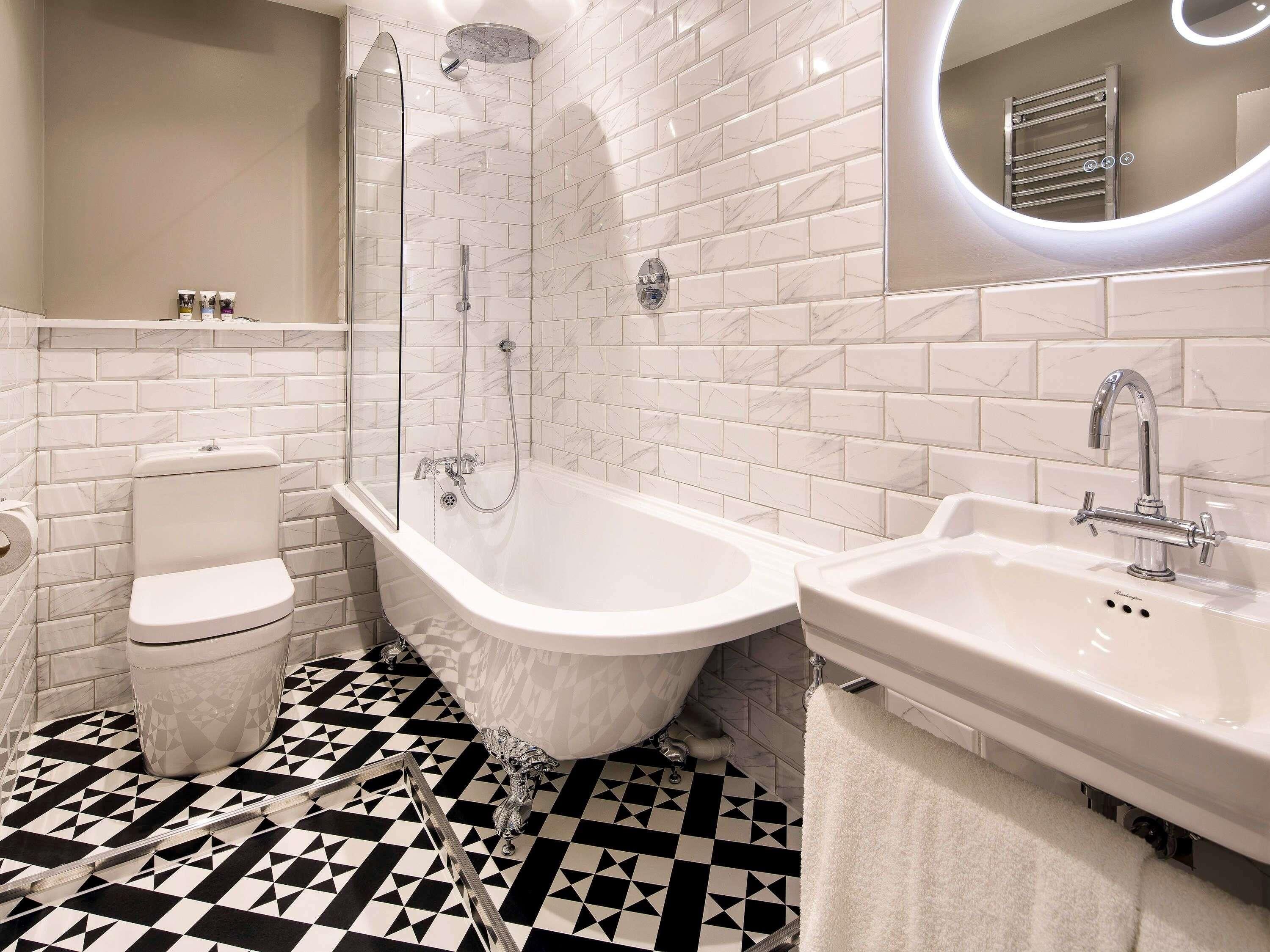 Un baño moderno con una bañera independiente, inodoro y lavamanos.