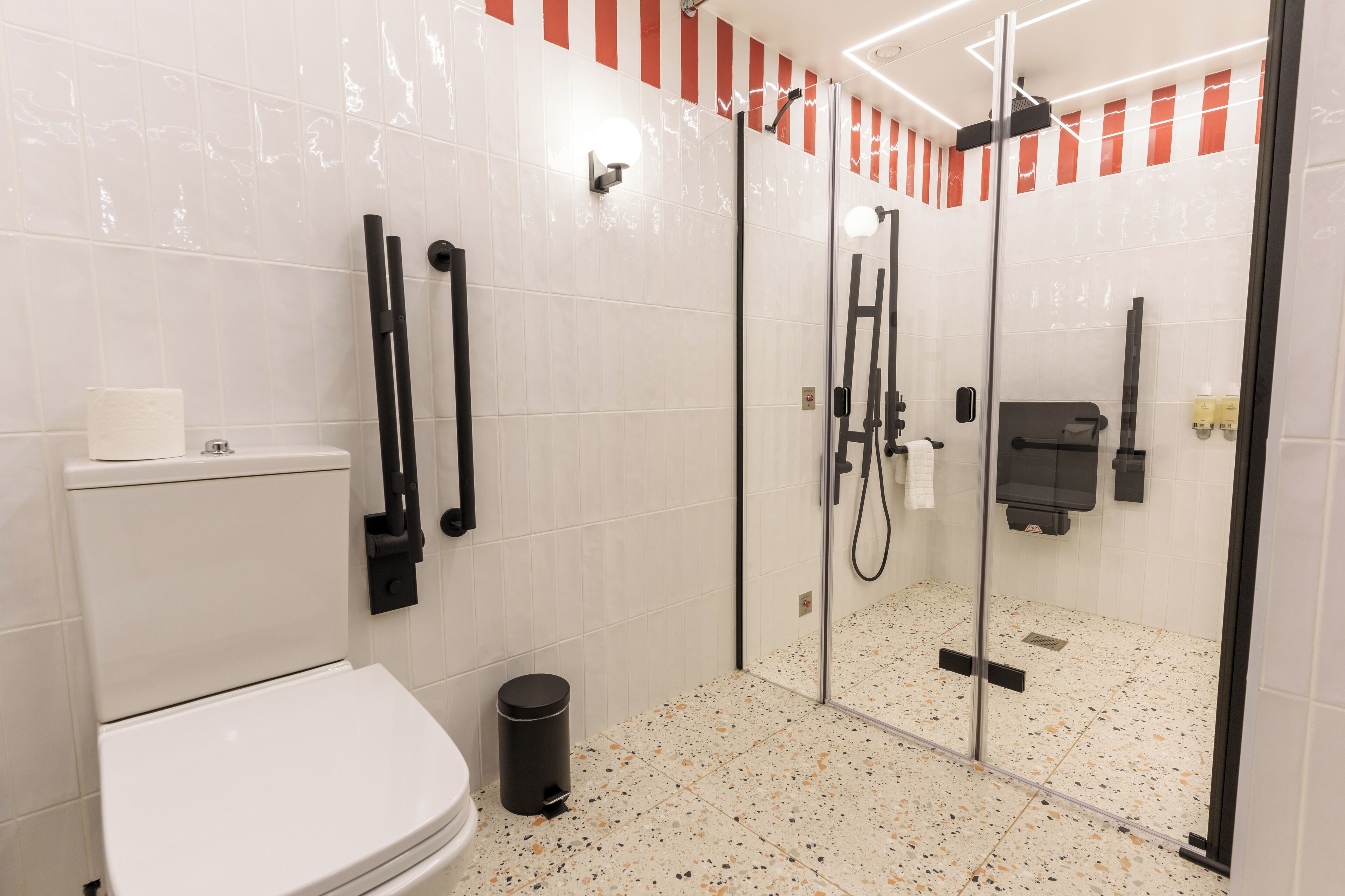 A modern bathroom with a toilet, bidet, and glass-enclosed shower area.