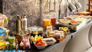 A breakfast buffet with various food items, beverages, and condiments.