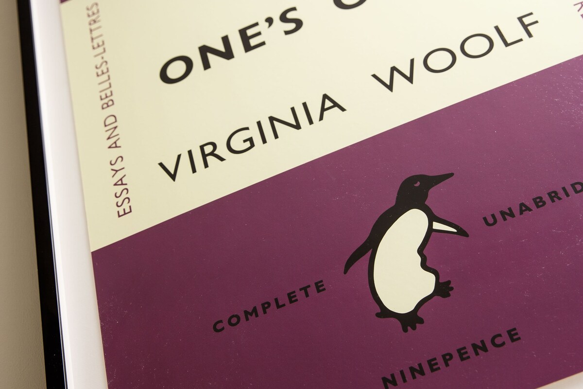 A framed book titled "A Room of One's Own" by Virginia Woolf, complete with a penguin illustration and the publisher's name.