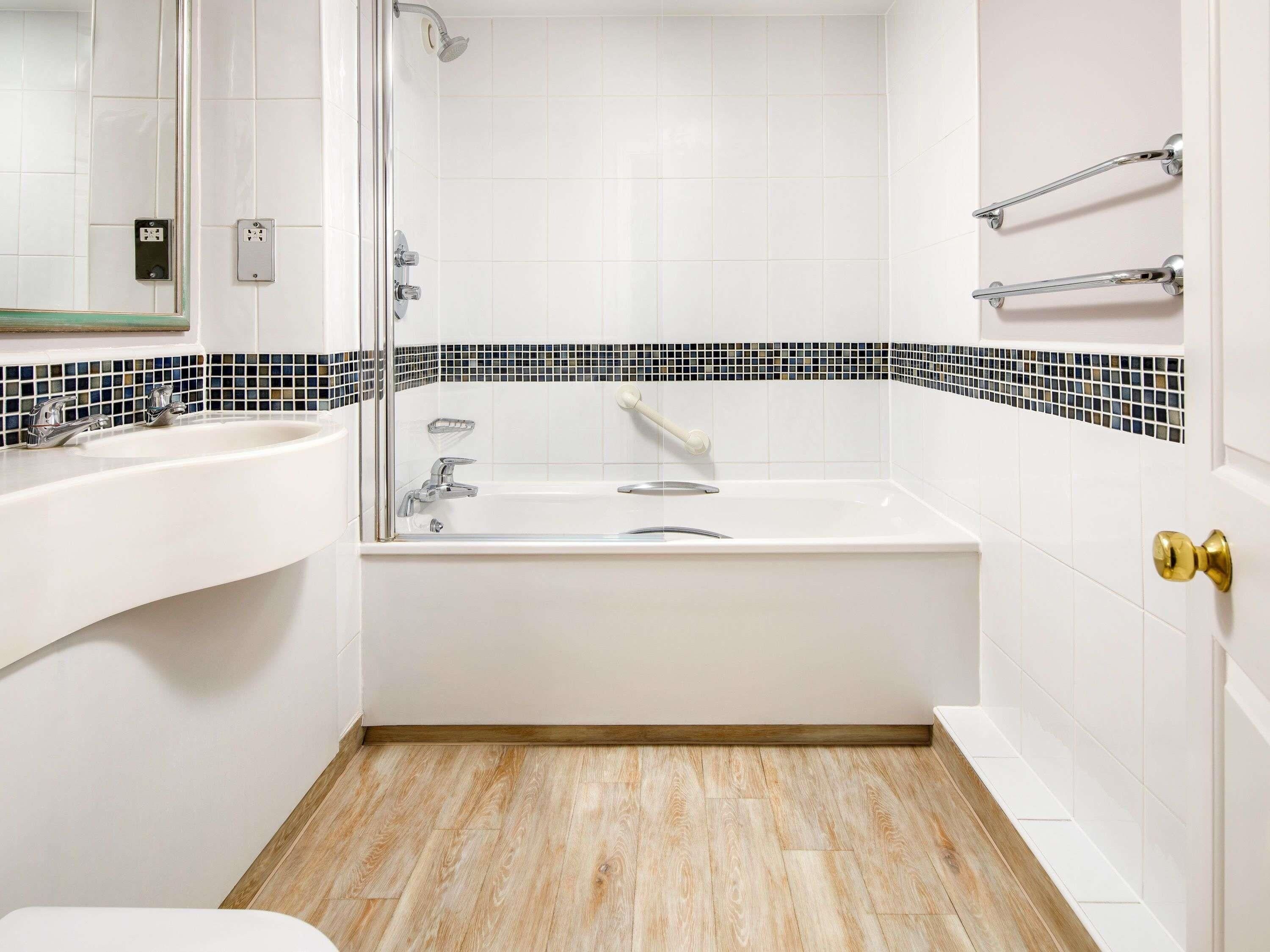 Un baño con lavamanos blanco, bañera y ducha.