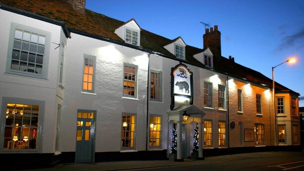 A traditional pub with a white facade, multiple windows, and a sign featuring a bear. - The Bear Hotel by Greene King Inns (Hungerford)