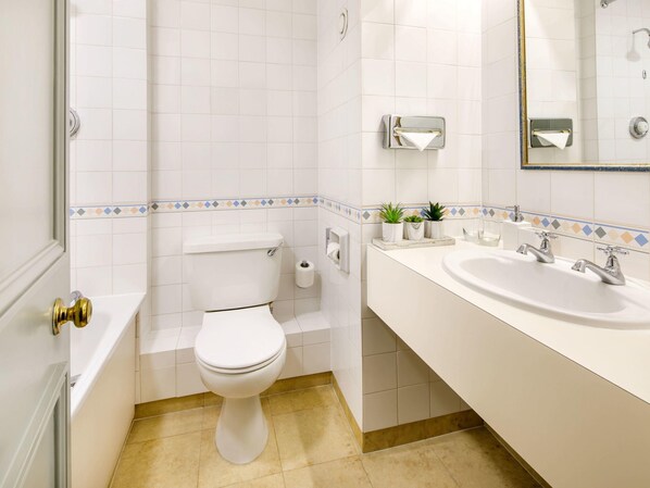 Une salle de bain avec des toilettes, un lavabo et un miroir.