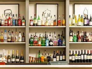 Un bar avec plusieurs étagères remplies de bouteilles de différentes sortes de spiritueux.