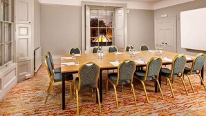 A conference room with a large table, chairs, and a whiteboard. - Mercure Bristol North The Grange Hotel (Bristol)