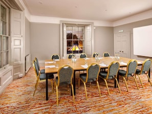 A conference room with a large table, chairs, and a whiteboard. - Mercure Bristol North The Grange Hotel (Bristol)