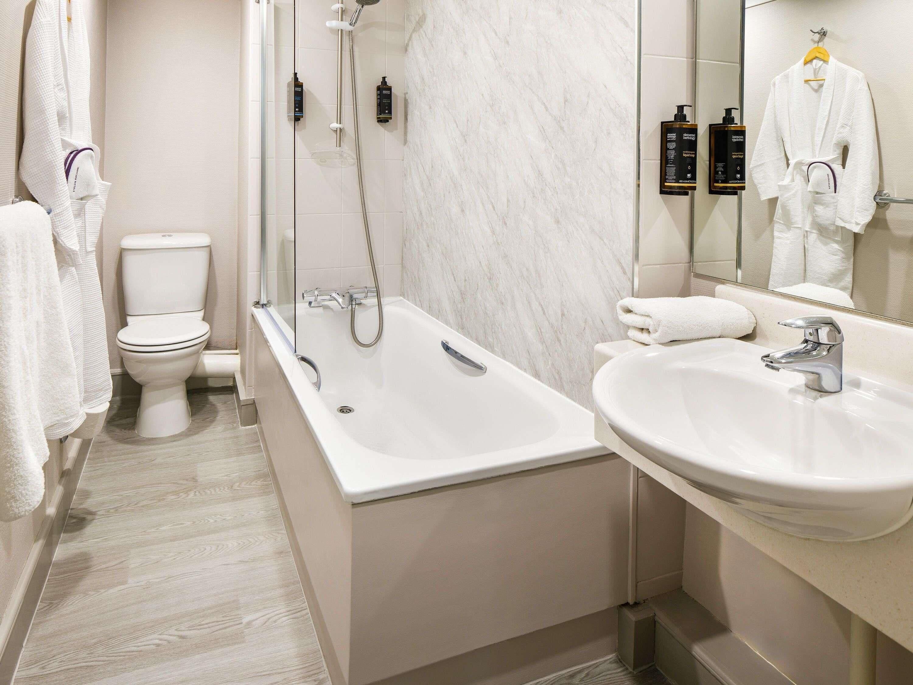 A modern bathroom with a bathtub, a sink, and a toilet.