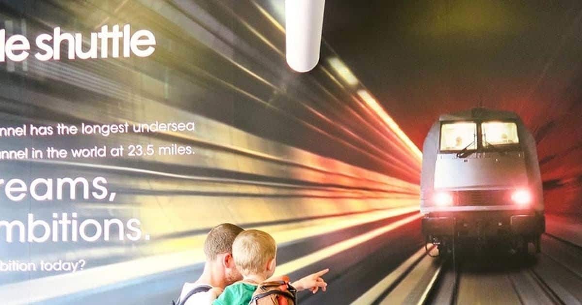A high-speed train in motion with a tunnel in the background.