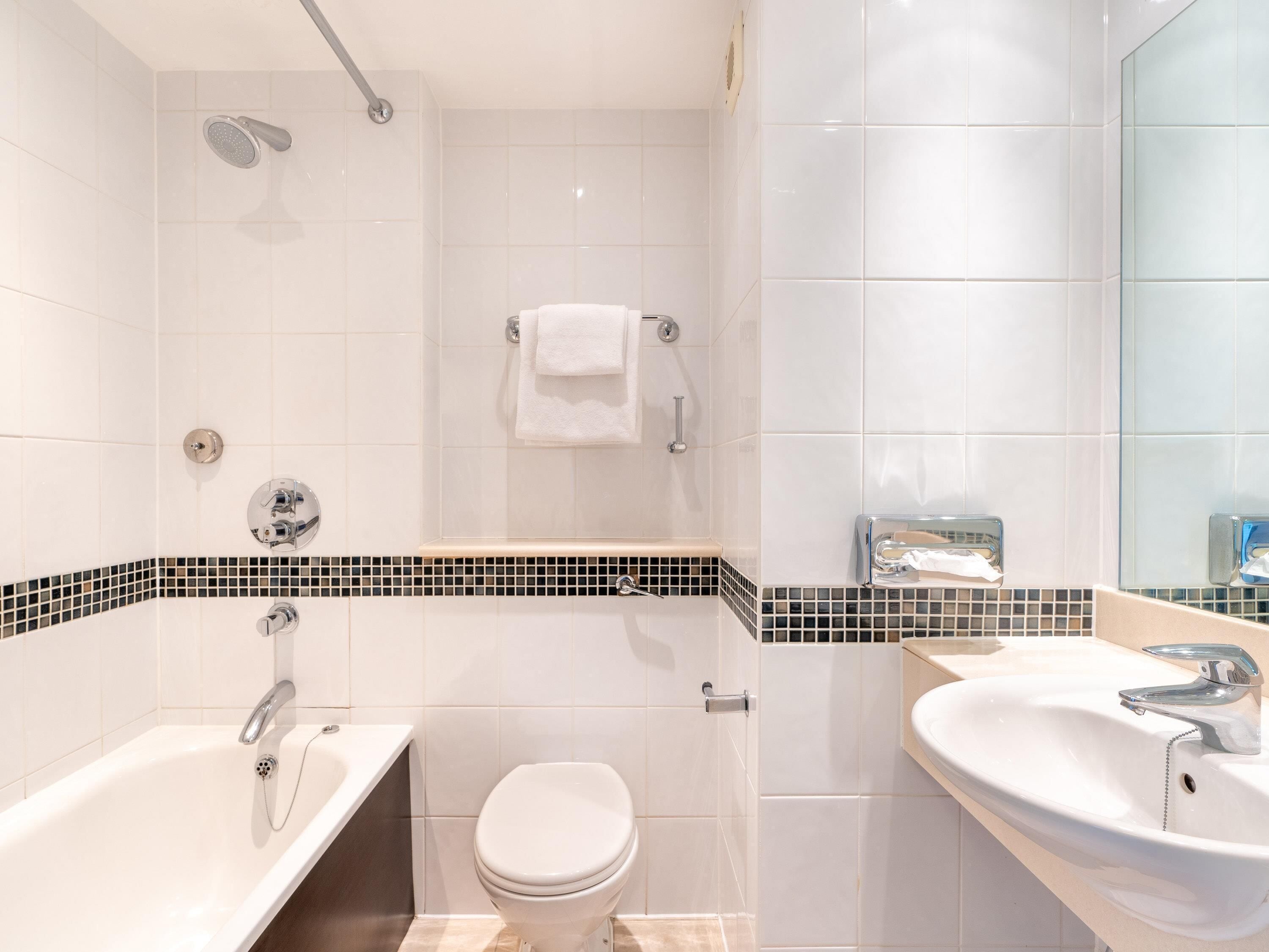 A modern bathroom with a bathtub, toilet, and sink.
