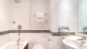 A modern bathroom with a bathtub, toilet, and sink.