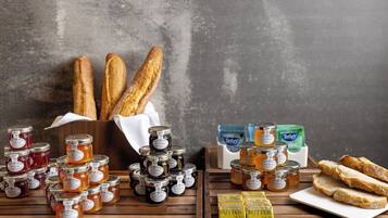 A display of bread, honey jars, and butter blocks on wooden shelves.