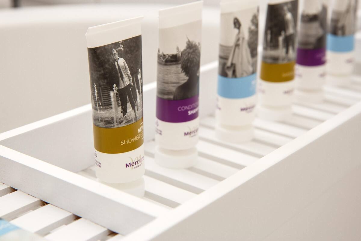 A row of toiletries on a white shelf.