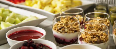 A variety of food items including fruits, yogurt parfaits, and a bowl of soup.