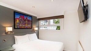 A hotel room with a large bed, bedside lamps, a painting on the wall, a window with a view, and a flat-screen TV mounted on the wall. - Mercure Chester Abbots Well Hotel (Chester)