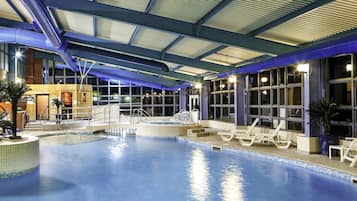 Una piscina cubierta, tumbonas