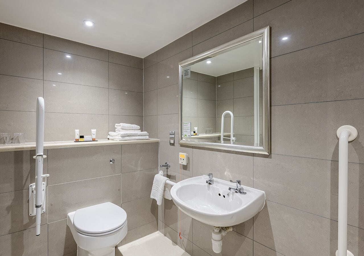 Een moderne badkamer met toilet, wastafel en douche.