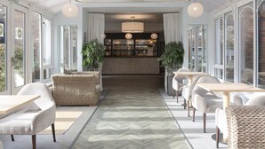 A modern interior with a central bar area, seating arrangements, and a sign indicating a health club. - The Hog's Back Hotel & Spa Farnham (Farnham)