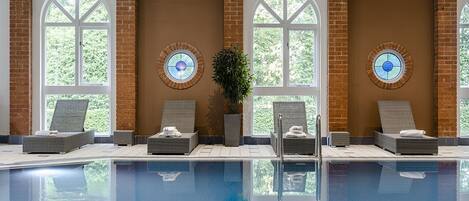 A pool area with lounge chairs and a potted plant.