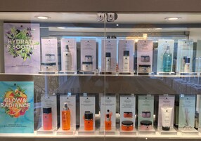 Exhibición de productos para el cuidado de la piel en una tienda con señalización e indicaciones claras.