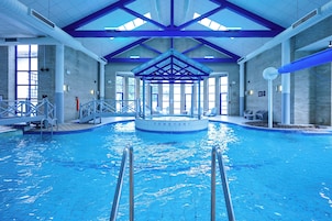 Una piscina techada, sillones reclinables de piscina