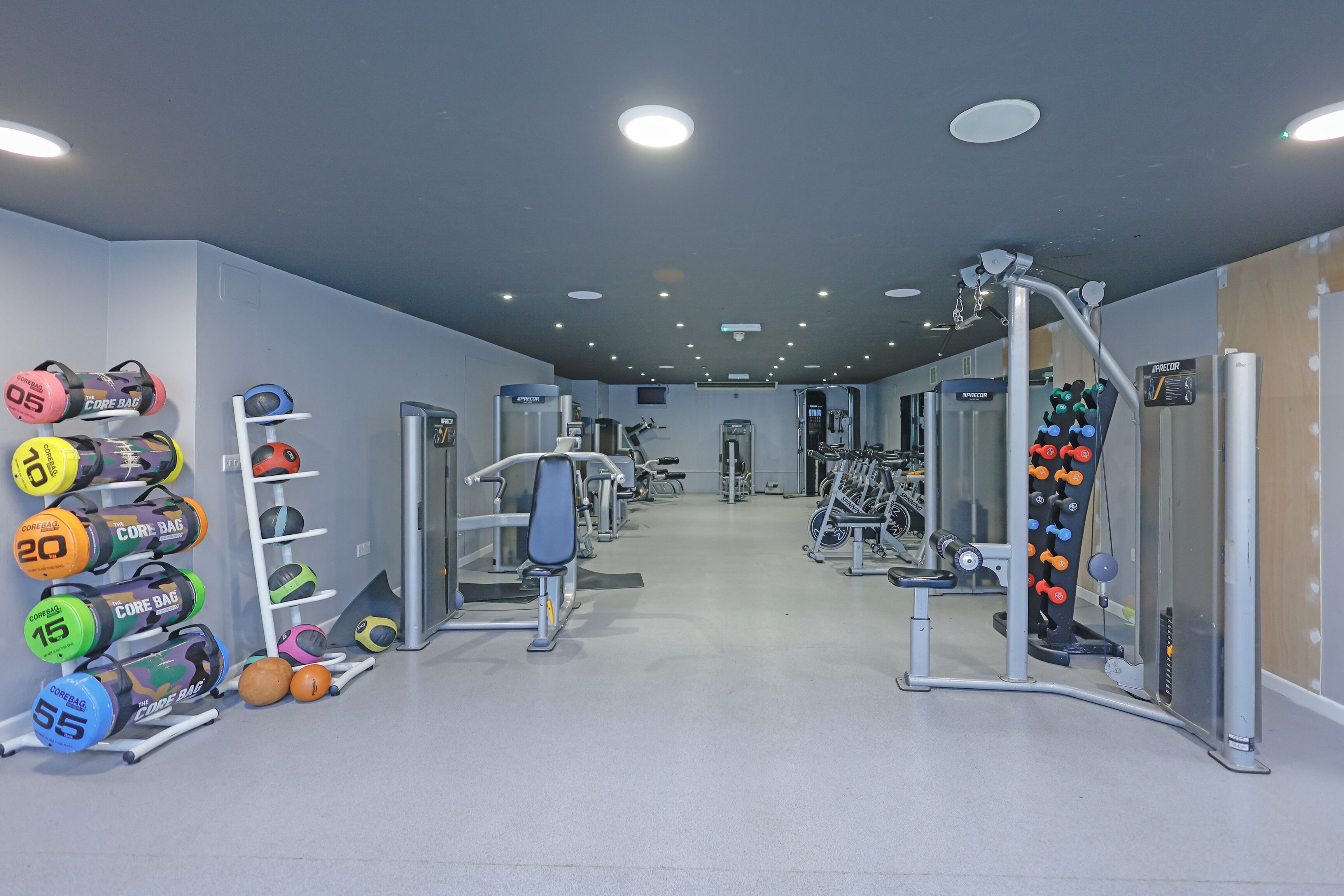 Un gimnasio con equipo de levantamiento de pesas, cintas de correr y máquinas de ejercicio.
