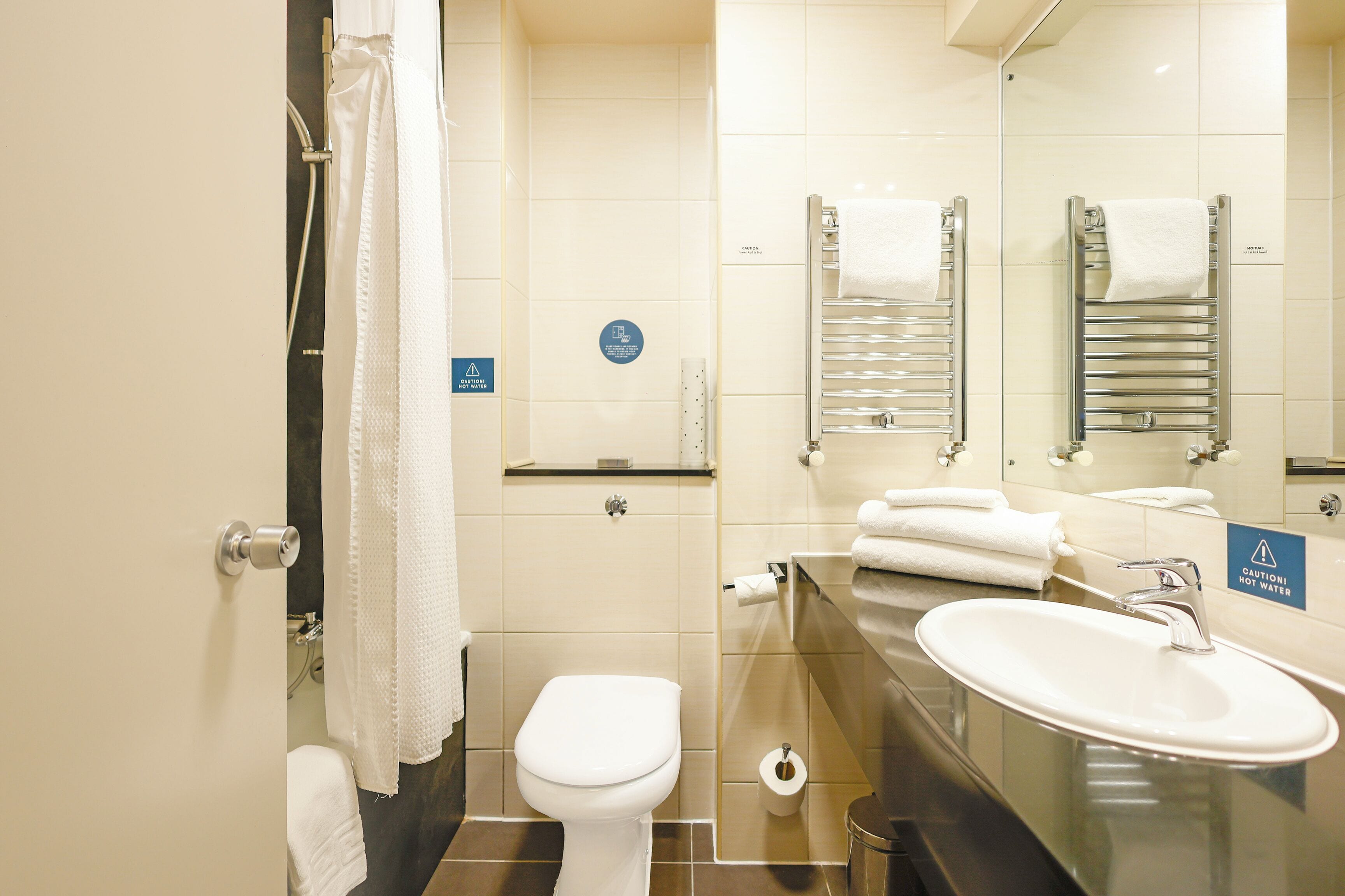 Un baño moderno con inodoro, lavamanos y toalleros.
