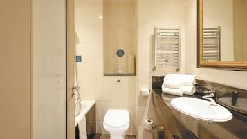 A modern bathroom with a toilet, sink, and towel rack.