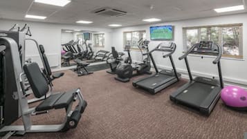A gym with treadmills, elliptical machines, and weight equipment.