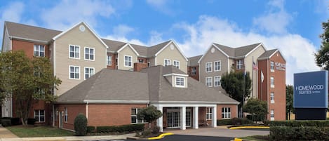 A hotel with a brick facade, multiple entry points, and a parking lot.