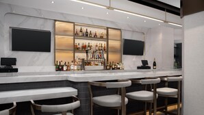 A modern bar area with a marble countertop, multiple liquor bottles, and bar stools.