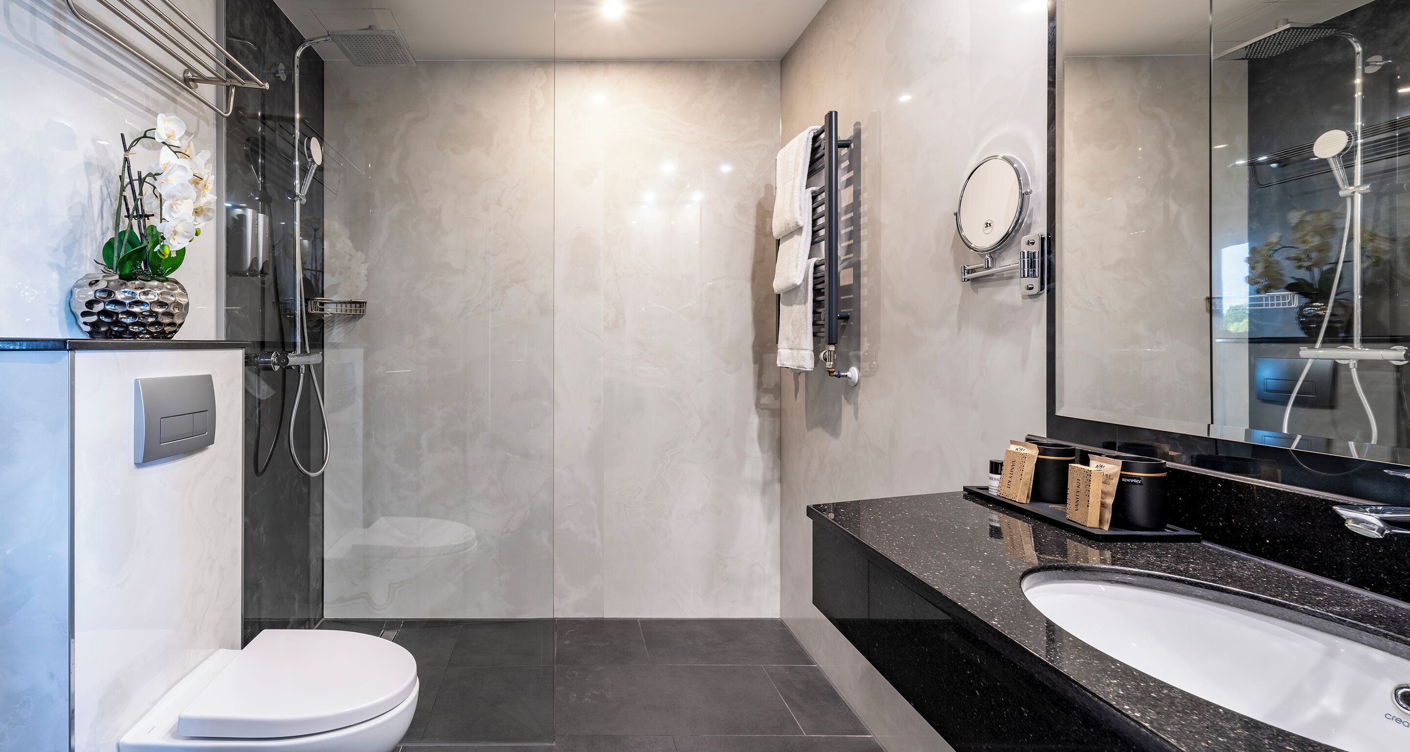 Un baño moderno con ducha, inodoro y lavabo.