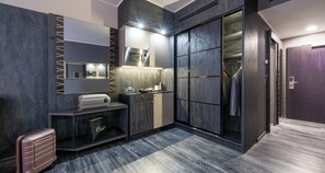 Une salle de bain moderne dotée d’un grand miroir, d’un four à micro-ondes encastré et d’un meuble-lavabo avec un distributeur de serviettes.