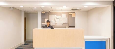 A reception desk with a sign that reads 'Holiday Inn Express' and a blue accent panel.