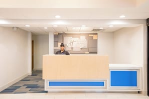 Un mostrador de recepción con un letrero que dice 'Holiday Inn Express' y un panel azul decorativo.