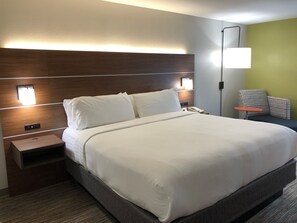 A hotel room with a large bed, bedside tables, a nightstand, a lamp, and a chair. - Holiday Inn Express Atlanta-Stone Mountain by IHG (Stone Mountain)