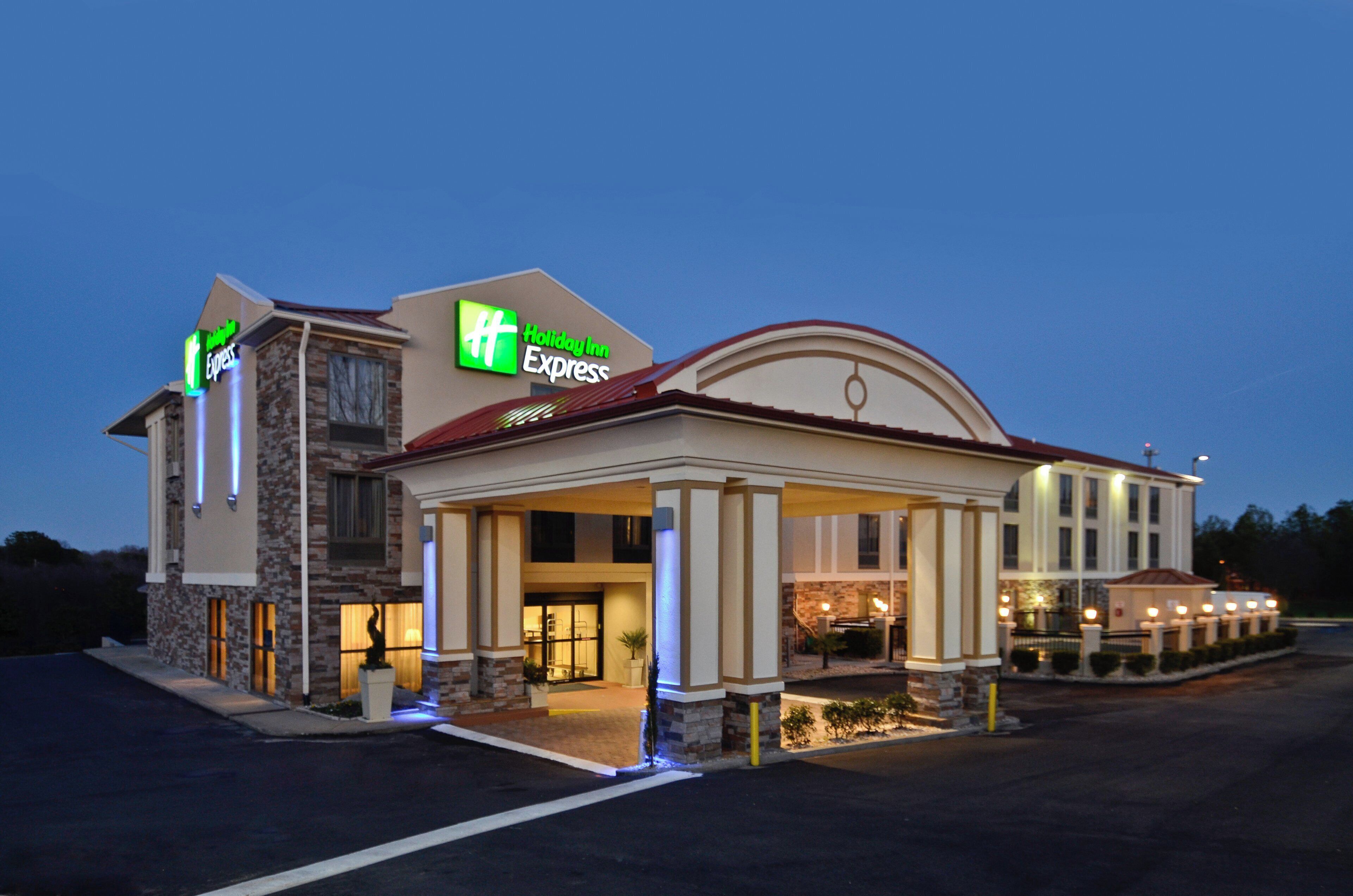 A Holiday Inn Express hotel with a stone facade, a covered entrance, and a parking lot.