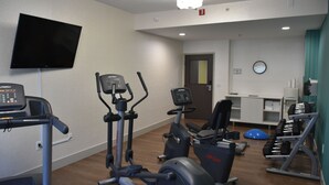 A gym with cardio machines, dumbbells, and a television. - Holiday Inn Express Atlanta-Stone Mountain by IHG (Stone Mountain)