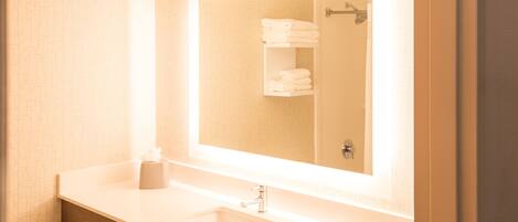 A bathroom with a white sink, a mirror, and a towel rack.