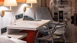 A hotel room with a bed, a desk with a telephone, two wall-mounted lamps, and a chair. - Best Western Hotel Leipzig City Center (Leipzig)