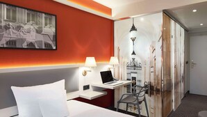 A hotel room with a bed, a desk with a laptop, two lamps, and a large painting on the wall. - Best Western Hotel Leipzig City Center (Leipzig)