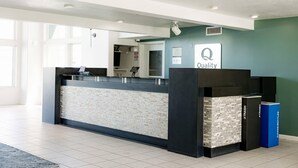 A reception area with a counter, a trash bin, and a sign indicating 'Quality'. - Quality Inn & Suites Lathrop - South Stockton (Lathrop)