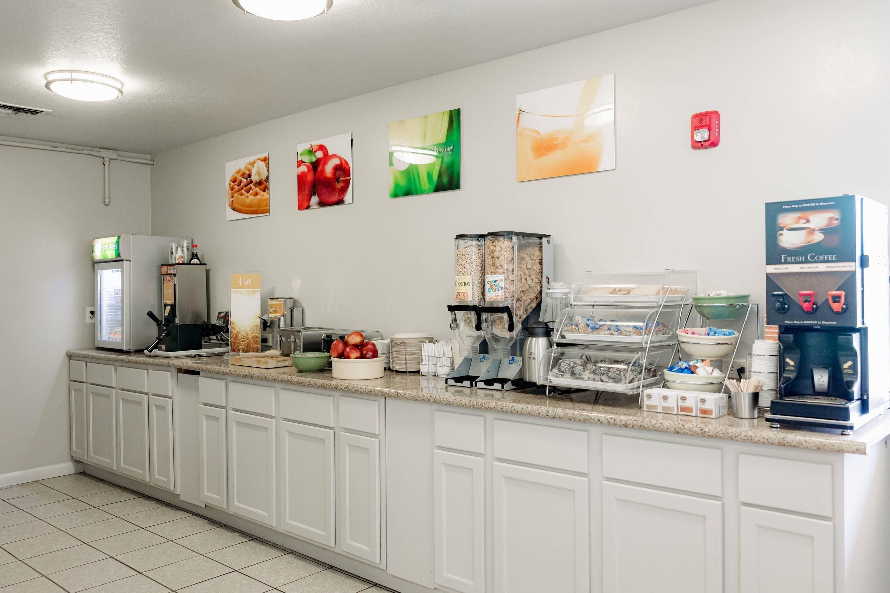 Una cocina limpia y ordenada con estación de café, frutero y varios electrodomésticos.