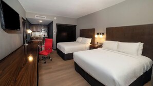 A hotel room with two beds, a desk, a chair, a TV, and a kitchenette. - Four Points by Sheraton Saltillo (Saltillo)