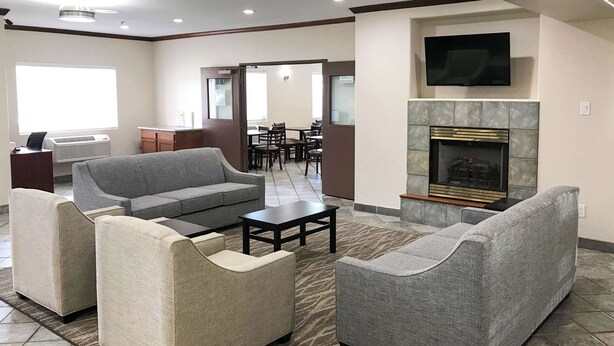Amplia sala de estar con chimenea, un televisor montado encima y un comedor al fondo.