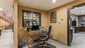 A hotel office with a wooden desk, black office chair, and a window. - Quality Inn & Suites Hendersonville - Flat Rock (Flat Rock)